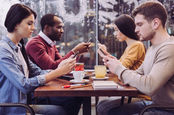 Young people stare vacantly at their mobile phones/ cellphones