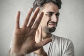 Disgusted man holds his hand up to obscure his view. Pic via Shutterstock