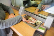 A person receiving cash from a teller