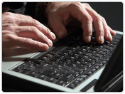 Man hands on computer. Image courtesy of Shutterstock