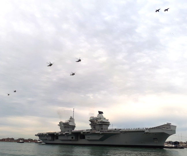 Royal Navy aircraft fly over HMS Queen Elizabeth as she enters Portsmouth Harbour. Pic: Gareth Corfield