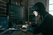 A woman in the classic black hoodie hacker shot