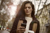 An angry woman looking at her phone